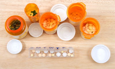 open pill bottles next to pill organizer