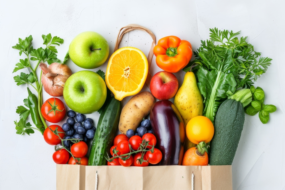 fresh fruits and vegetables spilling from paper bag