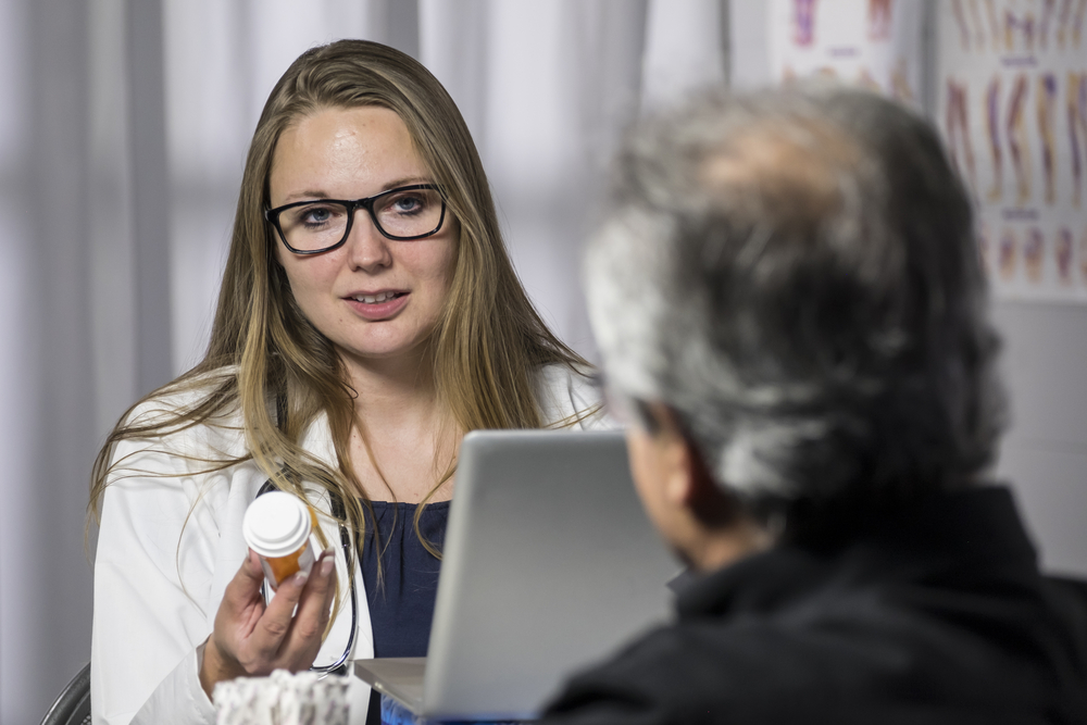 Man discussing pain management with pharmacist